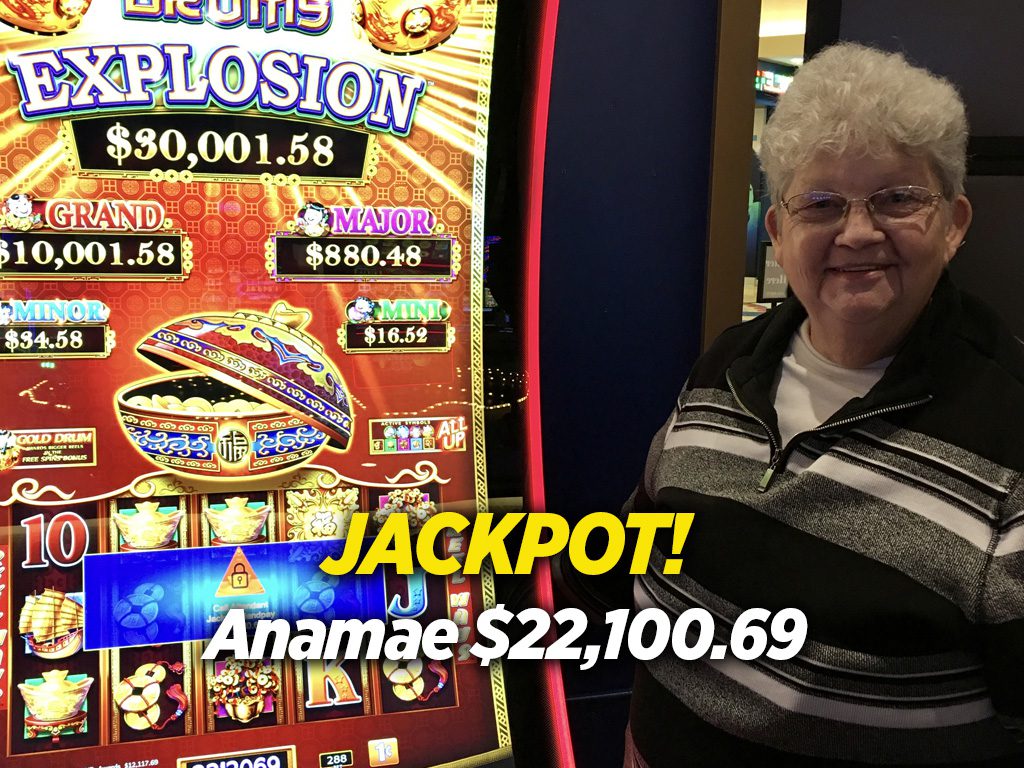 A woman standing in front of a slot machine that says jackpot.