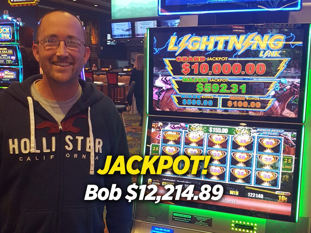 A man standing in front of a slot machine with the words lightwing jackpot.