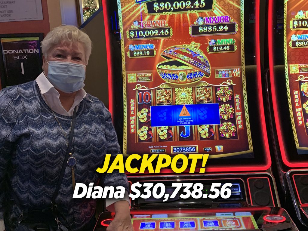A woman in a mask standing in front of a slot machine.