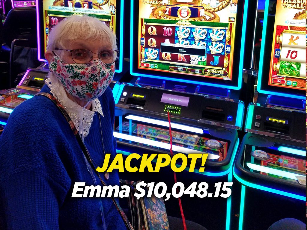A woman wearing a mask in front of a slot machine.