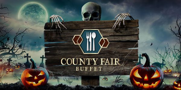 A spooky Halloween-themed image with a wooden sign reading "County Fair Buffet" held by skeleton hands. Carved pumpkins and tombstones are in the background under a moonlit sky.