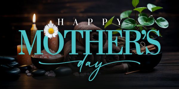 A spa setting with candles, towels, stones, and a plant, overlaid with the text "Happy Mother's Day.