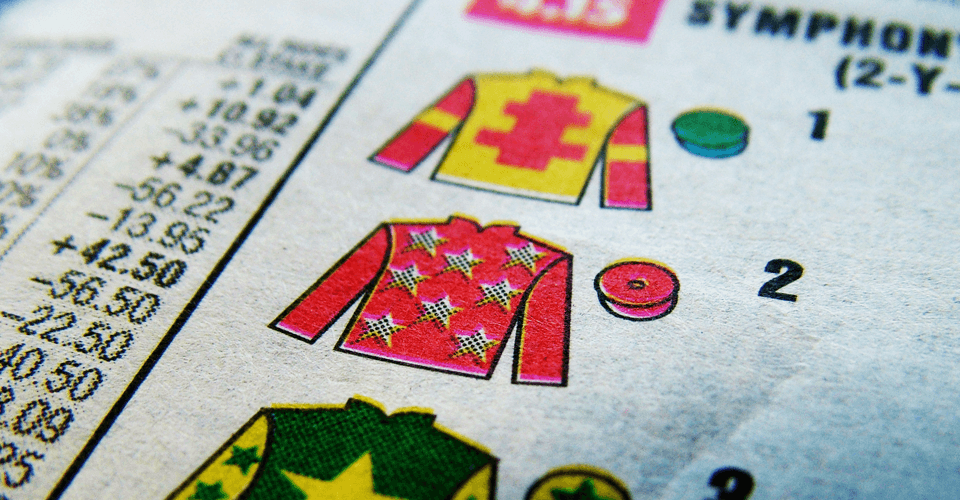 Close-up of a newspaper page showing colorful sewing patterns for children's sweaters, with visible text and numbers.
