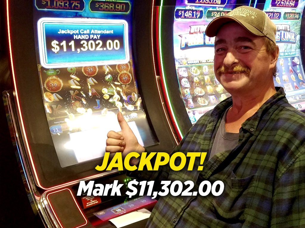 A man standing in front of a slot machine with the words jackpott.
