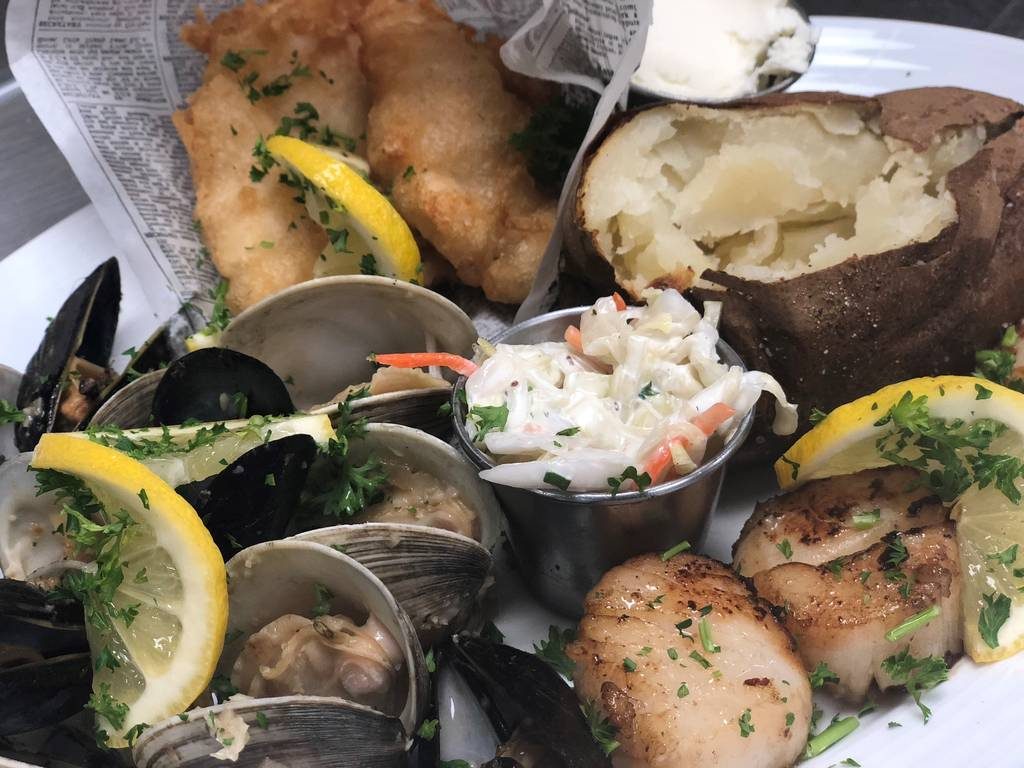 A plate of food that includes clams and potatoes.