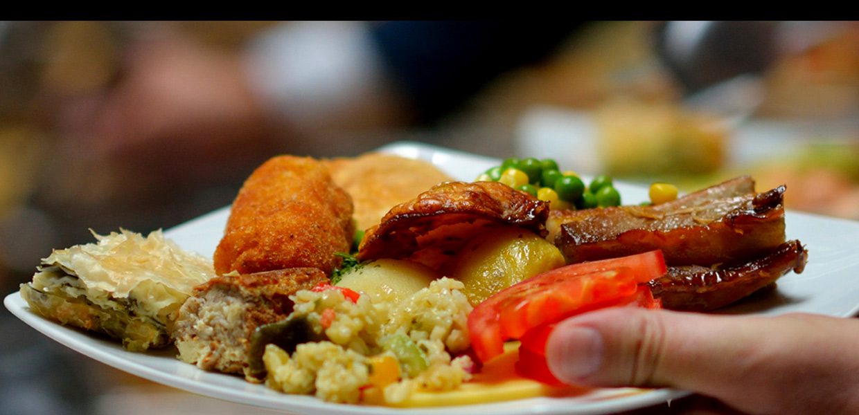 A plate of food with meat, rice and vegetables.