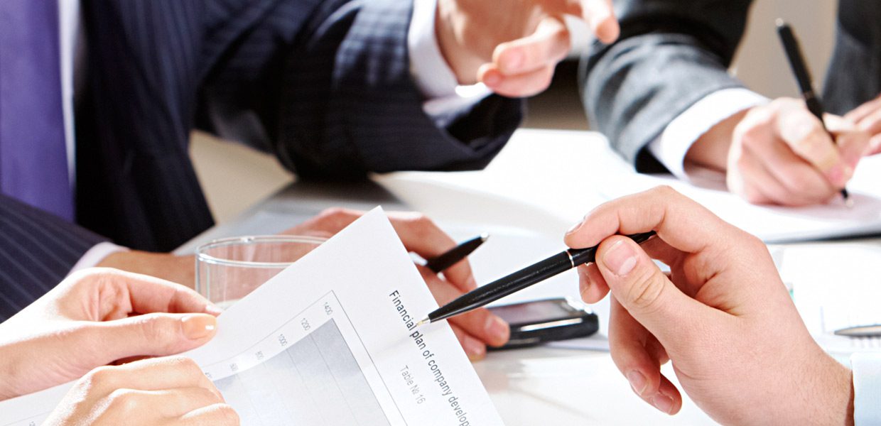 A person holding two pens and one pen in their hand