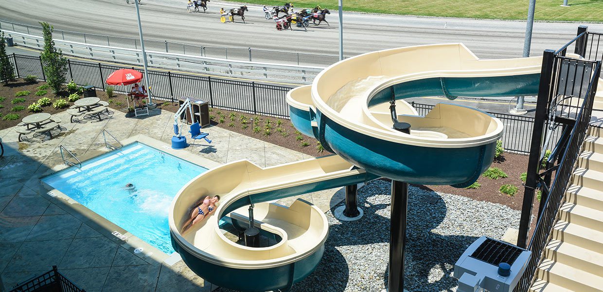 A couple of slides in the middle of an outdoor pool.