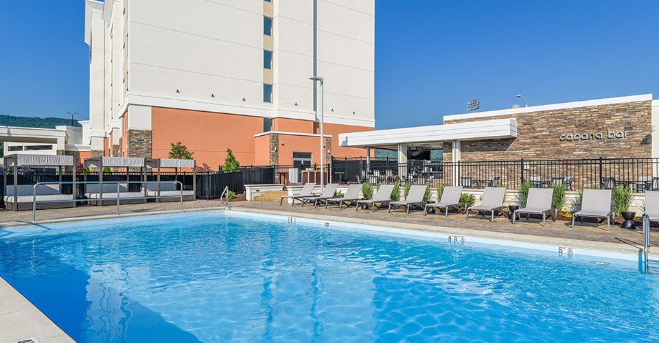 A pool with chairs and tables in the middle of it