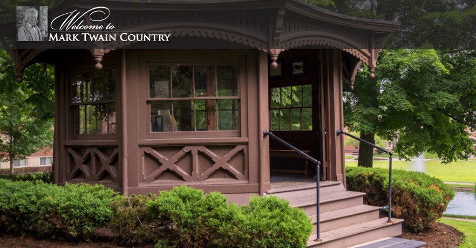 A brown building with a porch and steps leading to it.