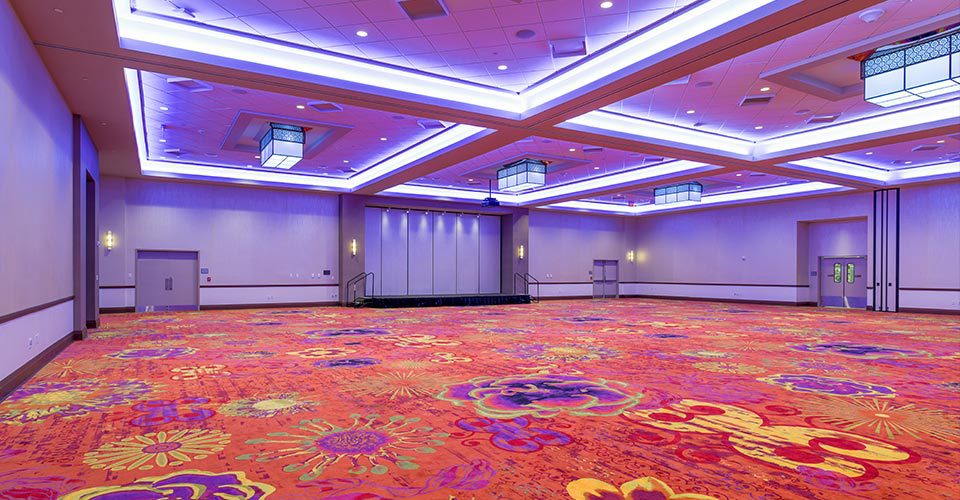 A large room with purple carpet and lights