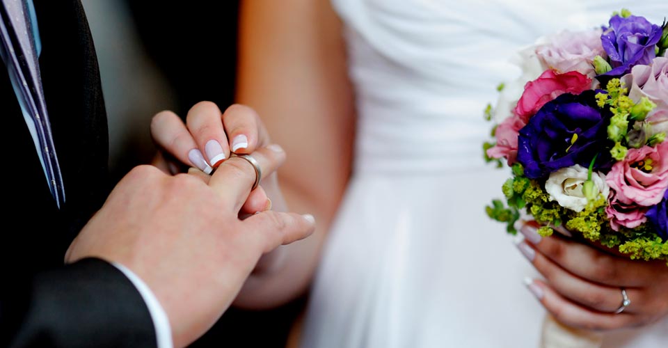 A man putting a wedding ring on his finger