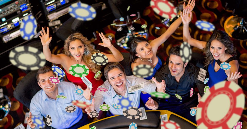 A group of people sitting around a table with chips on it.